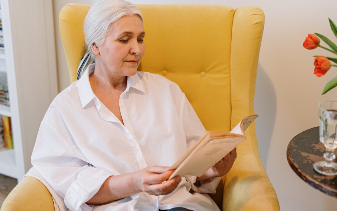 a woman sitting in a chair reading a book